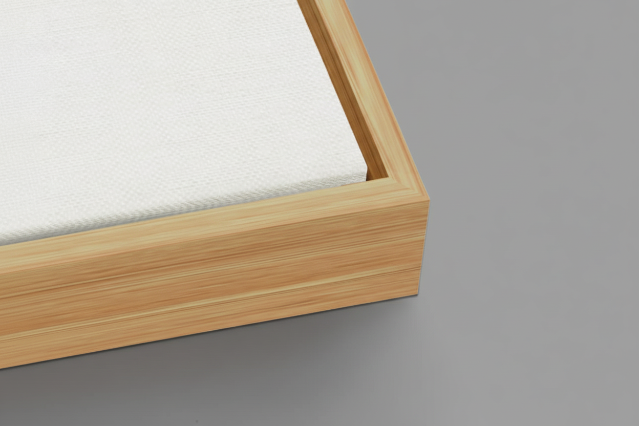 Close-up of a wooden picture frame with a white canvas on a light background
